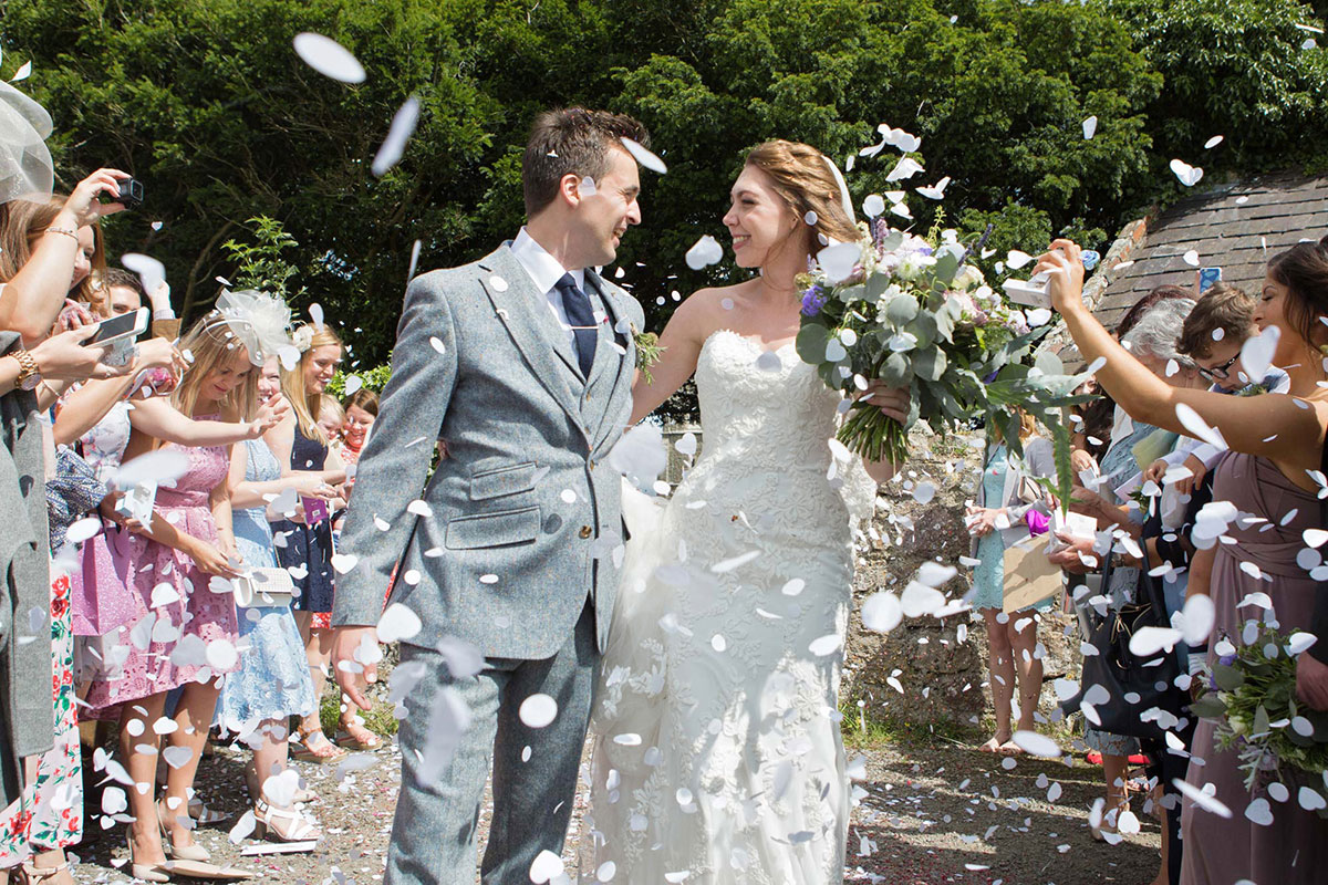 bride and groom walking through confetti at Llanedwen, Anglesey