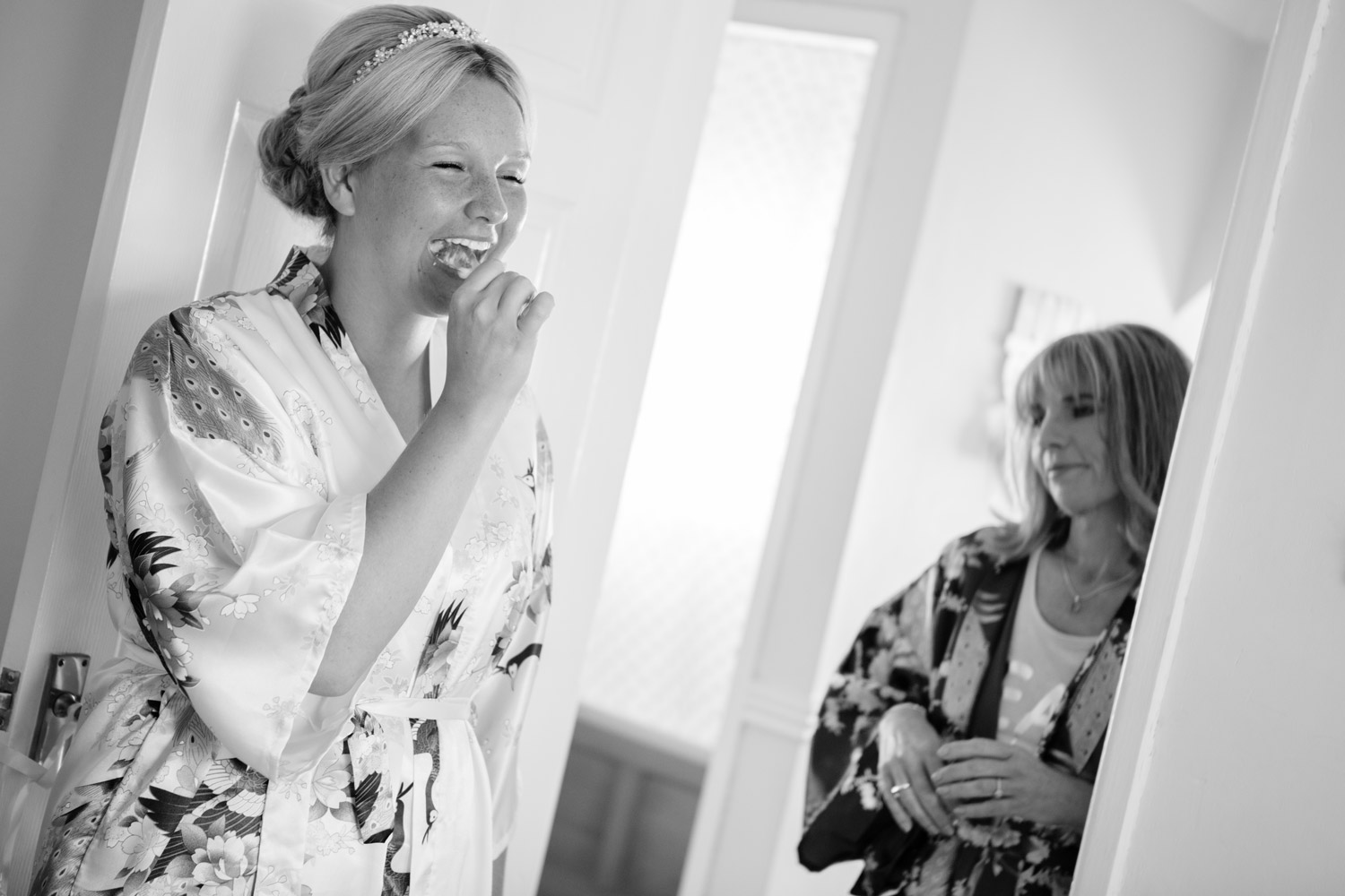 Trearddur Bay wedding bride brushing her teeth as her mum looks on full of emotion by Anglesey wedding photographer Gill Jones Photography
