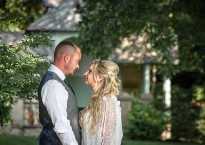bride and groom looking at one another, chest to chest, in the gardens at Chateau Rhianfa by the summer house by Anglesey family photographer Gill Jones