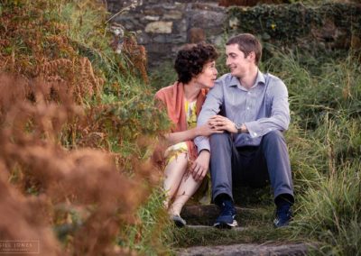 couple sitting side by side on steps around Holyhead Break water park by Anglesey wedding photographer Gill Jones