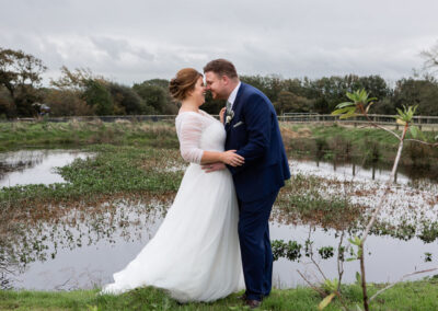 Bride and groom by the pond at Henblas, Anglesey