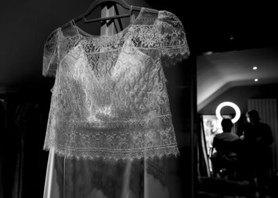 a delicate lace bolero fits over a wedding dress on a hanger by Anglesey wedding photographer Gill Jones Photography