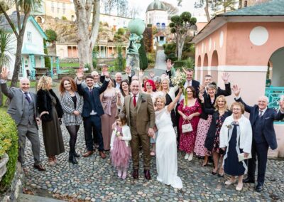 at Portmeirion village a group of guests cheer in celebration by Anglesey wedding photographer Gill Jones Photography