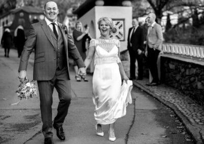 Laughing bride and groom walking through Portmeirion