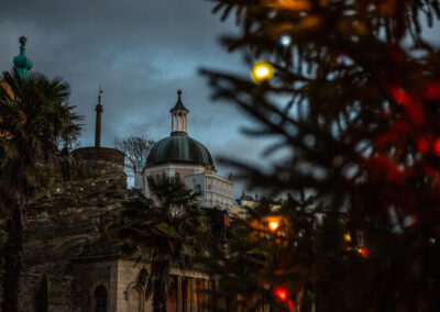 The Dome at Portmeirion village shown against a moody evening sky with a Christmas tree with coloured lights on by Anglesey wedding photographer Gill Jones Photography
