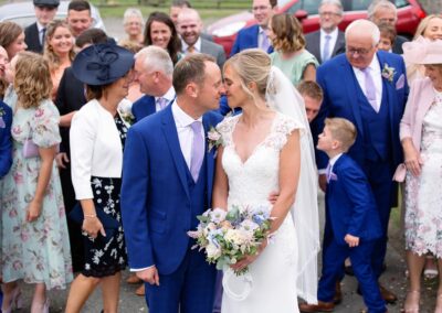 the bride and groom and their guests kissingat St. Mary's Church , Caerhun by Anglesey wedding photographer Gill Jones Photography