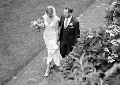 looking down at the bride and groom as they walk along a brick path at Bodnant Gardensby Anglesey wedding photographer Gill Jones