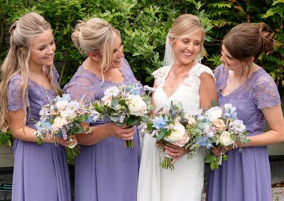the bride with her maids having a giggle at Bodnant food centreby Anglesey wedding photographer Gill Jones