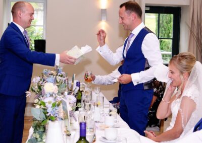 the groom accepts a tissue during the speeches at Bodnant food centre byby Anglesey wedding photographer Gill Jones