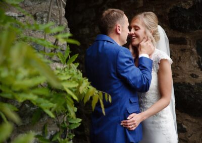 groom holds his brides face in his hands at Bodnant Food centreby Anglesey wedding photographer Gill Jones