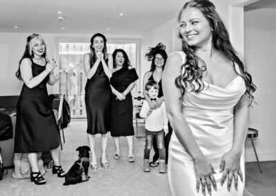 the bride shows her maids what she looks like in her wedding dress at Henblas, Anglesey by Anglesey wedding photographer Gill Jones