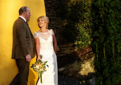 bride and groom standing in the setting sun at Portmeirion villageby Anglesey wedding photographer Gill Jones Photography