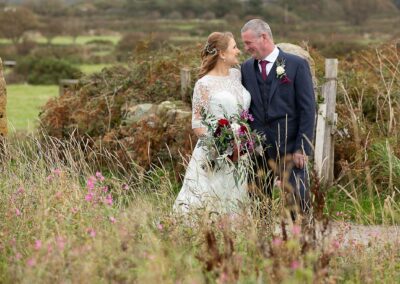bride and groom nose to nose within autumn flowersby Anglesey wedding photographer Gill Jones Photography