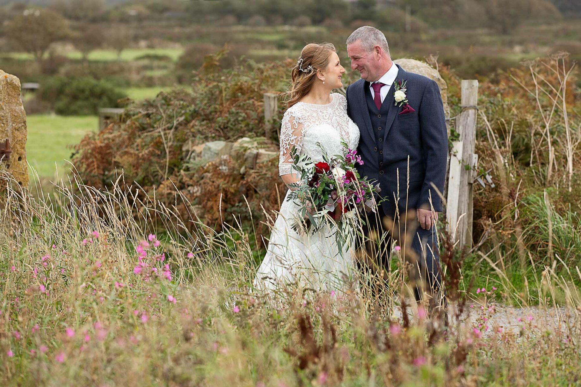 bride and groom nose to nose within autumn flowersby Anglesey wedding photographer Gill Jones Photography