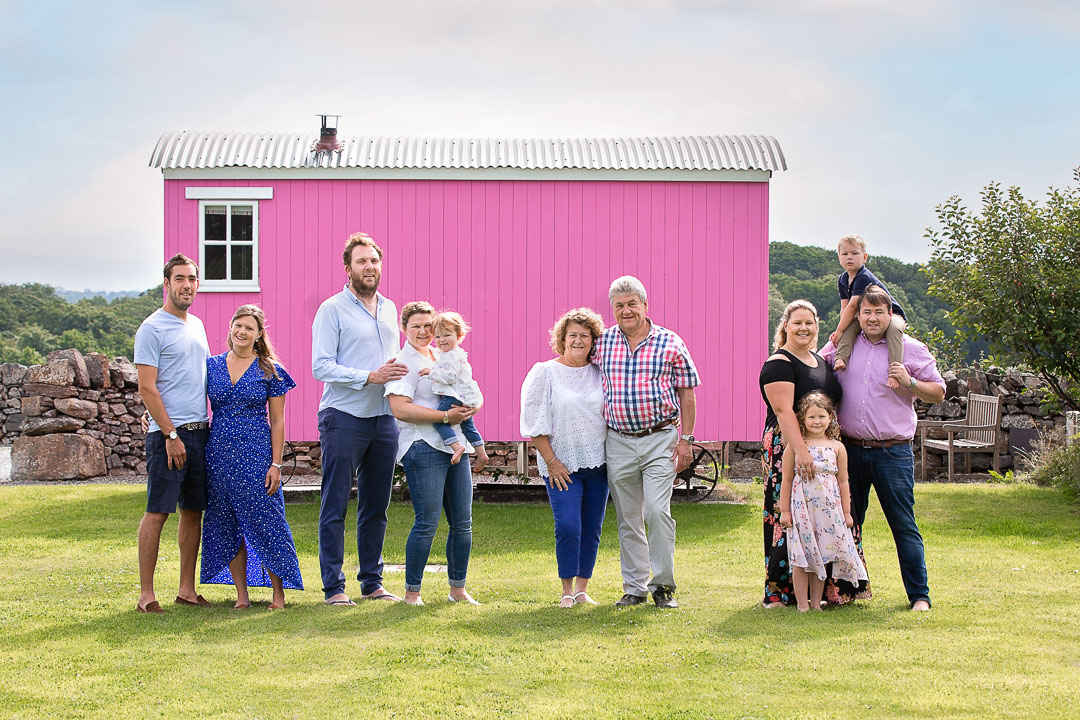 family in front of The Pink Hut at the outbuildings