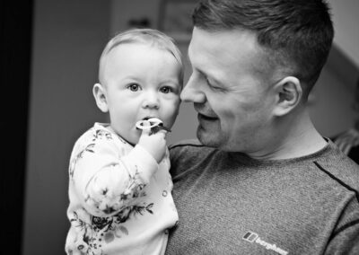 the groom hugs his baby daughter by Anglesey wedding photographer, North Wales, Gill Jones Photography