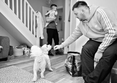 a groomsman reaches out towards the family dog by Anglesey wedding photographer, North Wales, Gill Jones Photography