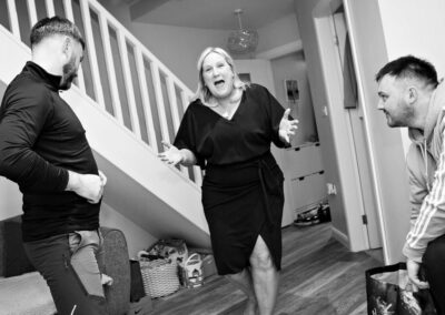 the groom's mother runs through the house with hands splayed outwards by Anglesey wedding photographer, North Wales, Gill Jones Photography