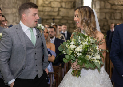 the groom lets out a sigh of relief as he sees his bride for the first time by Anglesey wedding photographer, North Wales, Gill Jones Photography
