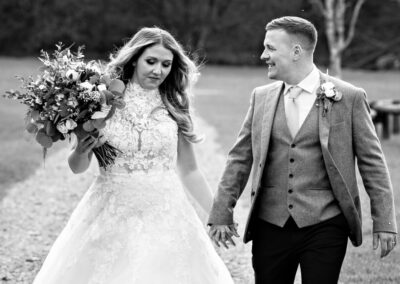 new husband and wife walk briskly along a path way by Anglesey wedding photographer, North Wales, Gill Jones Photography