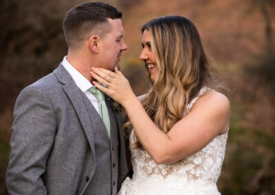 bride caresses the jaw line of her new husband by Anglesey wedding photographer, North Wales, Gill Jones PhotographyGill Jones Photographer