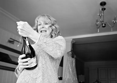 woman trying to open a bottle of champagne