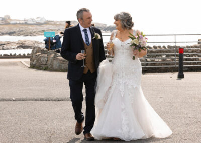 bride and groom happily walking and chatting outside the trearddur bay hotel