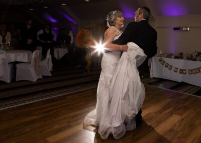 bride and groom's first dance with a beam of light in the background