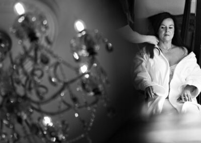 bride having her her done with chandelier twinkling by her side by Anglesey wedding photographer Gill Jones Photography