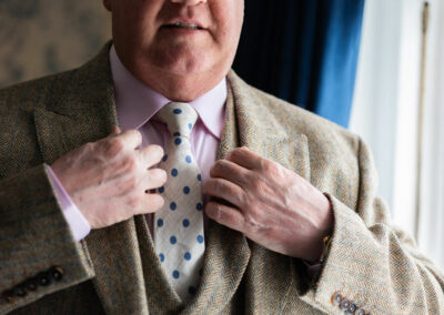 groom adjusting his lapels by Anglesey wedding photographer Gill Jones Photography