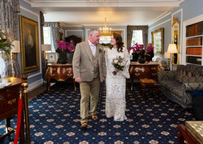 bride and groom walking out of their ceremony room hand in hand by Anglesey wedding photographer Gill Jones Photography