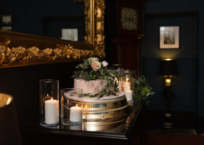 wedding cake with flowers on top surrounded by candles by Anglesey wedding photographer Gill Jones Photography