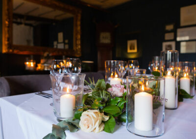 dining table with lit candles and flowers by Anglesey wedding photographer Gill Jones Photography