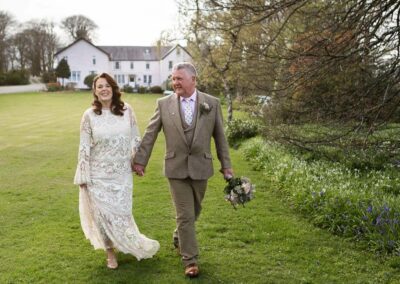 bride and groom hand in hand walking in in the gardens at Plas Dinas by Anglesey wedding photographer Gill Jones Photography