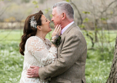 bride touches her groom's jawline affectionately by Anglesey wedding photographer Gill Jones Photography