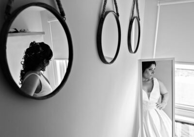 a bride prepares as we see reflections of her in two mirrors by Anglesey photographer Gill Jones Photography