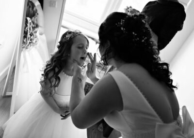 a bride cleans her daughter's face by Anglesey photographer Gill Jones Photography