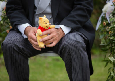 Grandfather holds Winnie the Pooh in his hands by Anglesey photographer Gill Jones Photography
