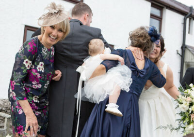 guests rejoice and kiss the bride and groom by Anglesey photographer Gill Jones Photography