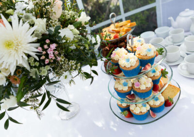 An afternoon spread of fairy cakes and flowers and teacups by Anglesey photographer Gill Jones Photography