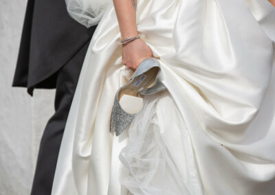 the brides hands hold her sparkly Jimmy Choo shoes by Anglesey photographer Gill Jones Photography