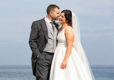 a groom whispers in his brides ear by Anglesey photographer Gill Jones Photography