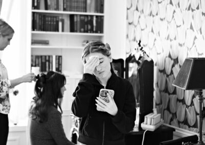 young girl looking at her reflection wiping makeup from her forehead by Anglesey wedding photographer Gill Jones Photography