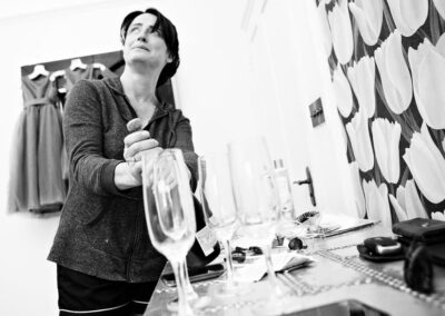 bride tries to take a cork out a champagne bottle by Anglesey wedding photographer Gill Jones Photography