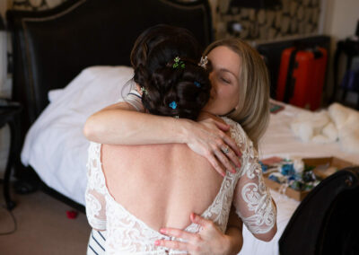 friend gives the bride a big hug by Anglesey wedding photographer Gill Jones Photography