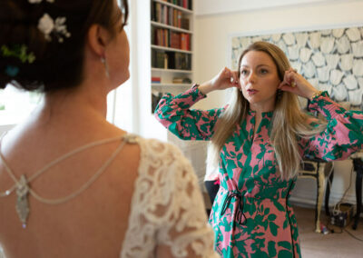 friend asks the bride which earrings she should wear for the wedding by Anglesey wedding photographer Gill Jones Photography