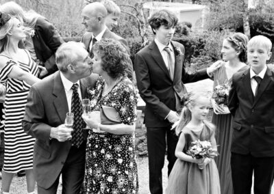 elderly couple in foreground kissing, younger couple in background reluctant to kiss by by Anglesey wedding photographer Gill Jones Photography