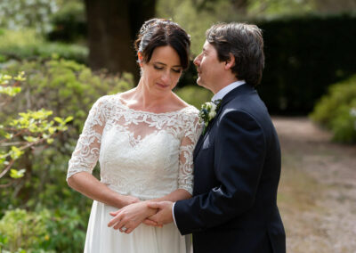 groom holding wrists of bride whispering in her ear by Anglesey wedding photographer Gill Jones Photography