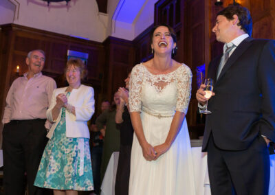 bride laughing out loud as guests look on by Anglesey wedding photographer Gill Jones Photography
