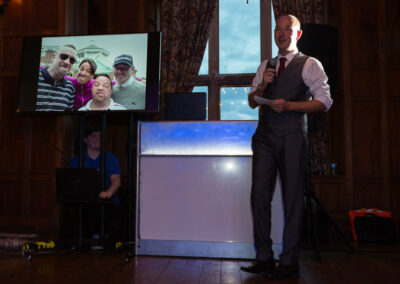 guest giving a speech with a screen to his right by Anglesey wedding photographer Gill Jones Photography